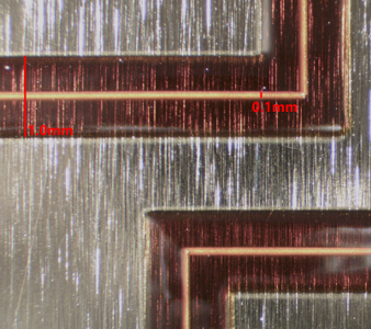 Micrograph showing NanoJet printed 100 micron silver trace encapsulated with 1 mm wide printed polyimide all on an aluminum substrate